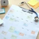 Calendário fiscal médico colorido organizado ao lado de prontuário e laptop