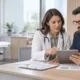 Médica gestora e administrador analisam dados financeiros em uma clínica ambulatorial